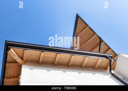 Neue Holz- warmen ökologischen Haus Dach mit Stahl Dachrinne regen System. Professionelle Konstruktion und Ablassrohre Installation. Umweltfreundliche Materialien. Stockfoto