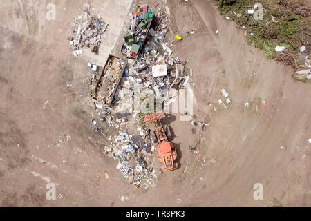 Orange Traktor arbeiten in einer Mülltrennung und Recycling Anlage, Luftaufnahmen. Stockfoto
