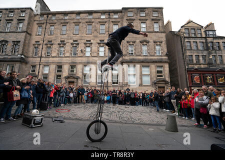 Street Interpret auf Einrad führt zu Gast auf der High Street Royal Mile in der Altstadt von Edinburgh, Schottland, Großbritannien Stockfoto