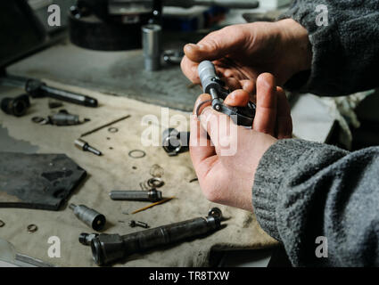 Mechanik reparieren einer Diesel-einspritzdüse. Worker's Hand ist auf ...
