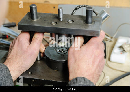 Mechanik reparieren einer Diesel-einspritzdüse. Worker's Hand ist auf einer Messmaschine. Ein Mann Maßnahmen einen Wertverlust von der Düse. Stockfoto