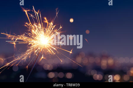 Wunderkerze mit unscharfen City Light Hintergrund, Frohes Neues Jahr Stockfoto