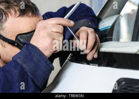 Reparatur Risse in der Frontscheibe. Kfz-Mechaniker repariert Risse im Glas. Stockfoto