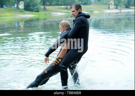 Männer, die in einem nassen Diver suit (Rettungsschwimmer), die die richtige Herausziehen ertrinken aus dem Wasser. August 10,2018. Kiew, Ukraine Stockfoto