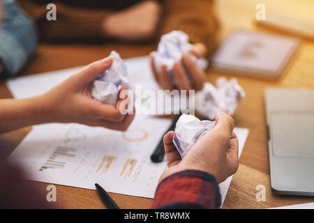 Ein Geschäftsmann vermasselt, Papiere, die von Hand mit Laptop, Tablet und Papier arbeiten auf dem Tisch in einer Besprechung Stockfoto