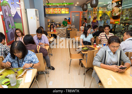 Manila, Philippinen - Juli, 26, 2016: Die Menschen essen Mittagessen in einem populären philippinischen Fast-Food-Kette Stockfoto