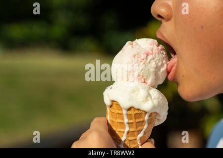 Junge Chinesen essen Vanille Eiscreme Kegel Stockfoto