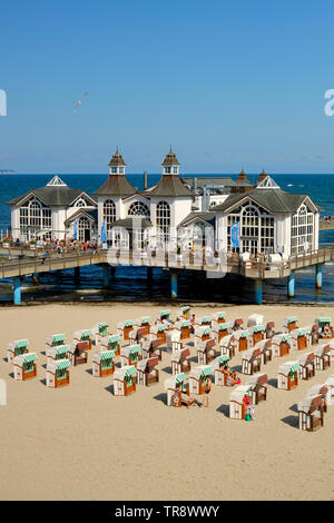 Liegestühle am Strand und die Seebrücke Sellin Ostseebad auf der Insel Rügen Deutschland. Seebrücke (Pier) mit einem im Stil der 1920er Jahre Pavillon. Stockfoto