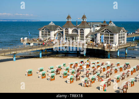 Liegestühle am Strand und die Seebrücke Sellin Ostseebad auf der Insel Rügen Deutschland. Seebrücke (Pier) mit einem im Stil der 1920er Jahre Pavillon. Stockfoto