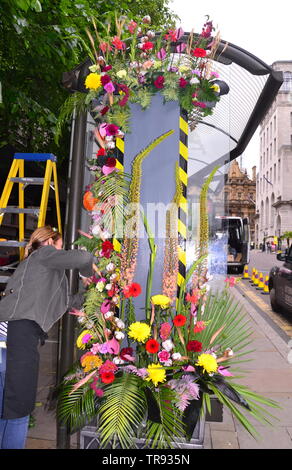 Der Manchester Flower Show, Teil der Manchester King Street Festival am 1.Juni - 2., 2019, bereitet zu öffnen. In diesem Jahr lautet das Thema: Flower Power! Blumen schmücken eine Bushaltestelle. Stockfoto