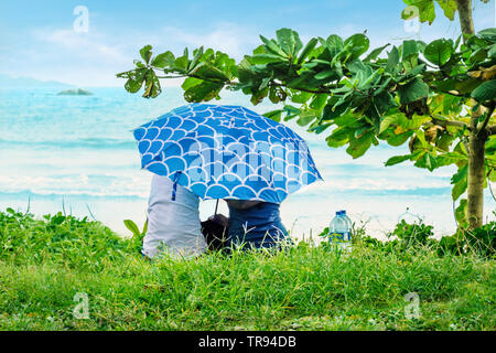 Asiatische Paar mit Sonnenschirm und Blick auf den Ozean. Liebhaber des Meeres zurückzog. Sri Lanka. Stockfoto