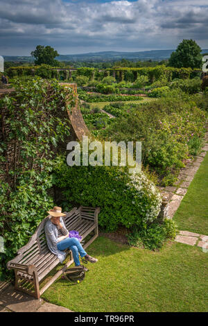 Eine Dame eine Auszeit nimmt und setzt sich die schöne Umgebung und die Ruhe des Hauses und Hestercombe Gardens in der Nähe von Taunton in Somerset zu bewundern. Stockfoto