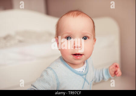 Cute Baby boy in Schlafanzug Nahaufnahme. Mit Blick auf die Kamera. Posing im Zimmer. Kindheit. Stockfoto