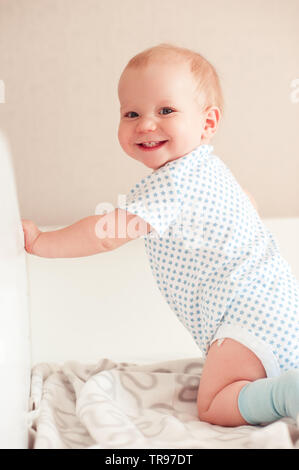 Smiling baby boy im Bett. Mit Blick auf die Kamera. Glück. Gesundes Kind. Stockfoto