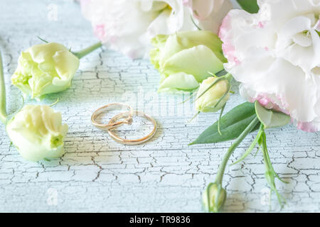 Blumenstrauß mit zwei goldene Ringe an den Holz- Hintergrund Stockfoto