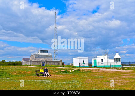 Berry Head ist eine felsige Klippe Landspitze in der Nähe von Brixam. Leuchtturm & altes Radio Station und Küstenwache lookout Gebäude. Paar sitzt auf der Bank. Stockfoto