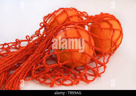 Handgefertigte string Tasche mit drei Orangen Stockfoto