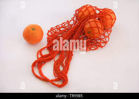 Handgefertigte string Tasche mit drei Orangen Stockfoto