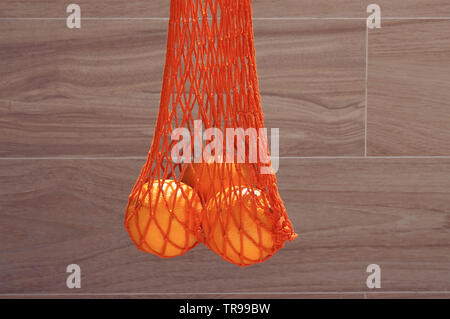 Handgefertigte string Tasche mit drei Orangen Stockfoto