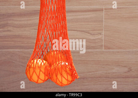 Handgefertigte string Tasche mit drei Orangen Stockfoto