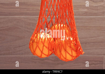 Handgefertigte string Tasche mit drei Orangen Stockfoto