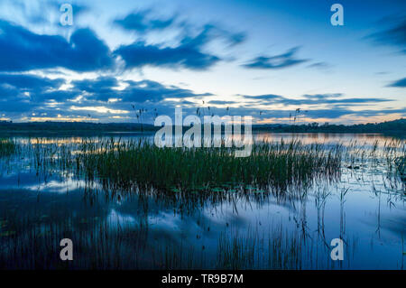 Bewölkter Himmel in einem See nach Sonnenuntergang wider Stockfoto