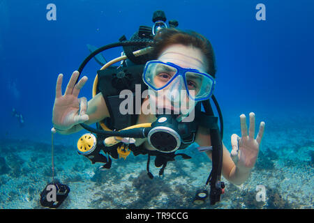 COZUMEL, MEXIKO: rothaarige Frau, Scuba Diver, ok Zeichen unter Wasser mit beiden Händen, mit einem blauen Maske Stockfoto