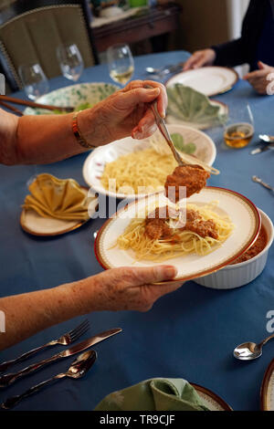 Ältere italienische Dame ist das Vorbereiten und Kochen ein Spaghetti Abendessen in Ihrer Küche für Freunde und Gäste auf Ihrem own​ Herd in Ihrer Küche zu Hause. Stockfoto