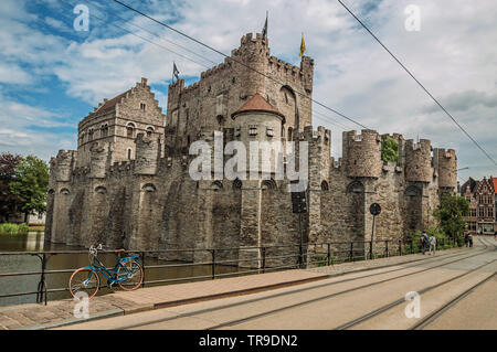 Brücke und Fahrrad vor der Burg Gravensteen an bewölkten Tag in Gent. Stadt mit intensiven kulturellen Lebens und gotischen Gebäuden in Belgien. Stockfoto
