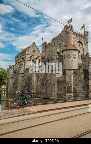Brücke und Fahrrad vor der Burg Gravensteen an bewölkten Tag in Gent. Stadt mit intensiven kulturellen Lebens und gotischen Gebäuden in Belgien. Stockfoto