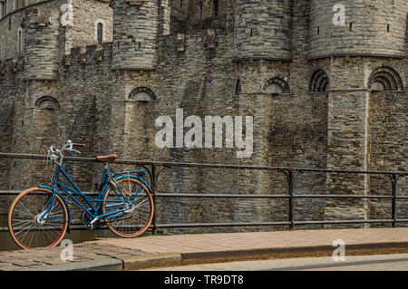 Brücke und Fahrrad vor der Burg Gravensteen an bewölkten Tag in Gent. Stadt mit intensiven kulturellen Lebens und gotischen Gebäuden in Belgien. Stockfoto