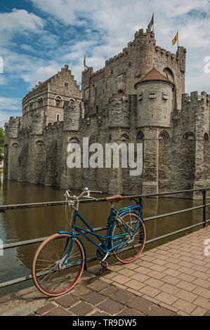 Brücke und Fahrrad vor der Burg Gravensteen an bewölkten Tag in Gent. Stadt mit intensiven kulturellen Lebens und gotischen Gebäuden in Belgien. Stockfoto
