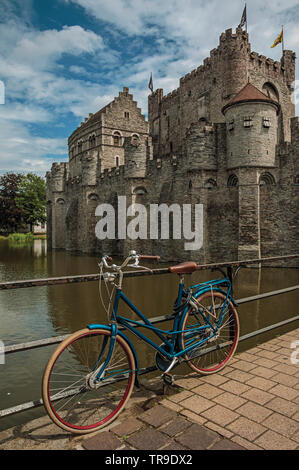 Brücke und Fahrrad vor der Burg Gravensteen an bewölkten Tag in Gent. Stadt mit intensiven kulturellen Lebens und gotischen Gebäuden in Belgien. Stockfoto
