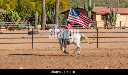 Wöchentliche Rodeo im White Stallion Ranch, eine Dude Ranch außerhalb von Tucson, AZ. Die amerikanische Flagge, immer der Start des Rodeo. Stockfoto