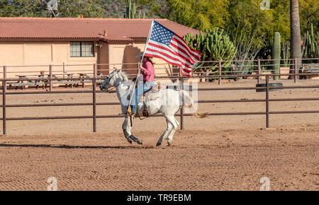 Wöchentliche Rodeo im White Stallion Ranch, eine Dude Ranch außerhalb von Tucson, AZ. Die amerikanische Flagge, immer der Start des Rodeo. Stockfoto