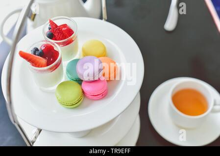 Der traditionelle englische Nachmittagstee mit Bunte Macarons und Desserts Stockfoto