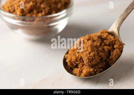 Brauner Zucker in Metalllöffel auf helle, Marmor Hintergrund mit kopieren. Dessert Zutat, Zucker süchtig Stockfoto