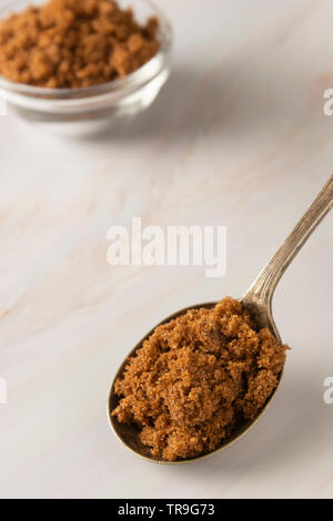 Brauner Zucker in Metalllöffel auf helle, Marmor Hintergrund mit kopieren. Dessert Zutat, Zucker süchtig, kopieren Raum Stockfoto