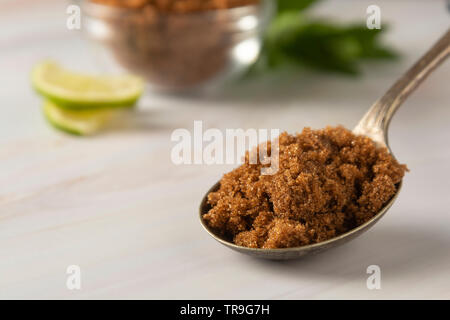 Brauner Zucker in Metalllöffel auf helle, Marmor Hintergrund mit kopieren. Dessert Zutat, Zucker süchtig, kopieren Raum Stockfoto