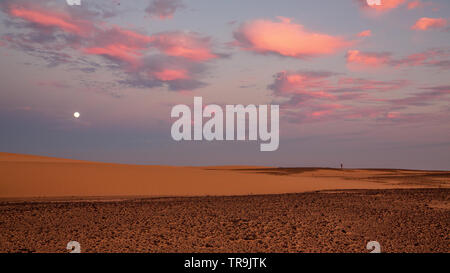 Einen schönen afrikanischen Sonnenuntergang in der westlichen Wüste des Sudan mit bunten Wolken und Himmel und die flache Landschaft der Wüste Stockfoto