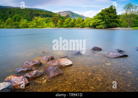 Lange Belichtung der Felsen und Wasser am See Coniston im Lake District National Park Stockfoto