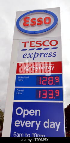 Schild mit Benzinpreisen in einer Tesco Express-Garage mit Esso-Markennamen in Ardwick, Manchester, Deutschland Stockfoto