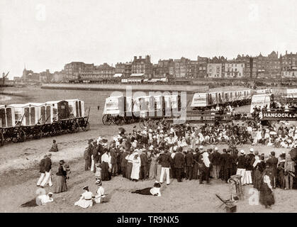 Jahrhundert Blick auf Strand Hütten und Masse beobachten Strand Unterhaltung in Margate, einer Stadt am Meer in Thanet, Kent, South East England. Margate hat eine führende Badeort und ein traditionelles Urlaubsziel für Londoner mit schönen Sandstränden, für mindestens 250 Jahre. Stockfoto