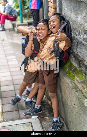 Ubud, Bali, Indonesien - Januar 2019: Jungen in der Schule uniform Spielen auf der Straße von Ubud Stockfoto