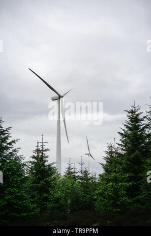 Zwei horizontale-achse Windenergieanlagen juxtapositioned mit einem Wald auf dem Schwarzen Gesetz Windfarm in der Nähe des Dorfes Climpy. Stockfoto