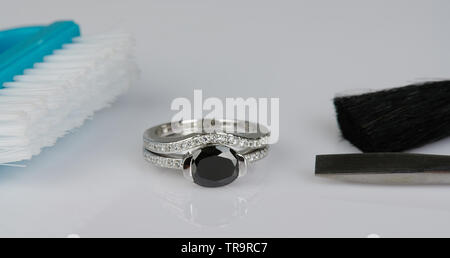 Reinigung von Schmuck Ring Thema. Gold Ring mit schwarzem Stein Stockfoto