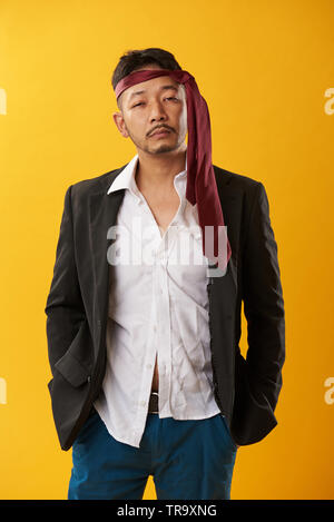 Portrait von asiatischer Mann nach dem Kater auf gelbem Hintergrund Stockfoto