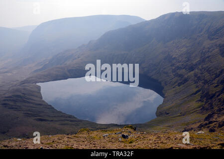 Blea Wasser und Mardale Kranke Bell aus rauen Felsen aus dem Wainwright High Street im Nationalpark Lake District, Cumbria, England, UK. Stockfoto