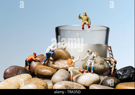 Miniatur Menschen Zahlenangaben Kletterfelsen und Kerze auf einem blauen Hintergrund Stockfoto