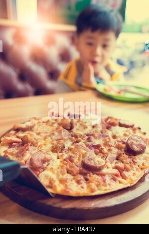 Pizza verschwommen und unscharf cute Boy auf bokeh Hintergrund, Stockfoto